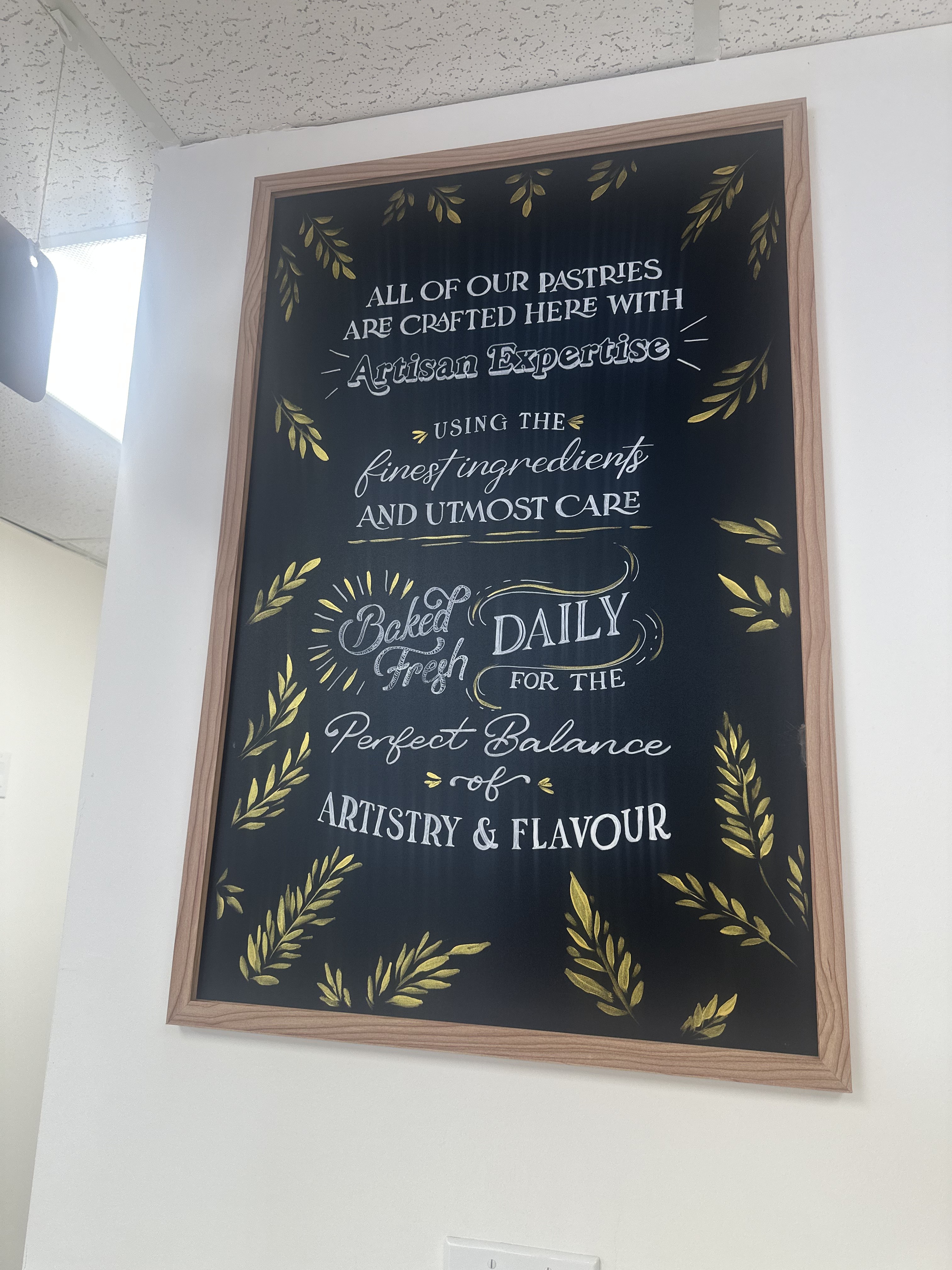 Hand-lettered chalkboard inside Rosarya reading Baked Fresh Daily
